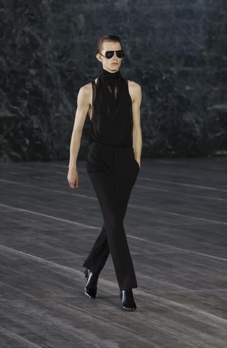 Model walking down the runway in an all black look at Saint Laurent.